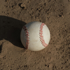 Baseball ball concept in field dirt.