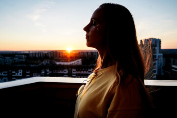 happy woman enjoying the sunset on the balcony