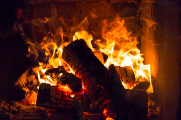 The firewood is burning with an orange fire in the fireplace. Heating of the house without electricity..