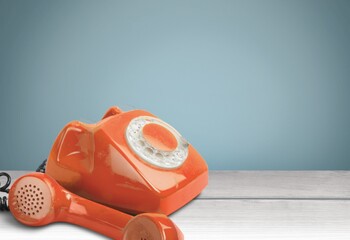 A retro red old telephone on a table.