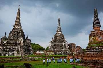 Fototapeta premium Ayutthaya, Thailand - October 5, 2022: Student touring pagoda Wat Phra Sri Sanphet Temple in the precinct of Ayutthaya, Historical Park, a UNESCO World