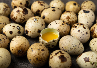 Obraz premium Quail eggs on black texture background. Whole and broken quail eggs. Natural products. Place for text. Fresh quail eggs. Protein. Calcium.