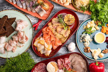 Snacks, fish, salted bacon, cheese, meat appetizer on a white background, side and top view