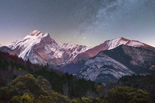 Snowy mountains under starry sky at night - Powered by Adobe