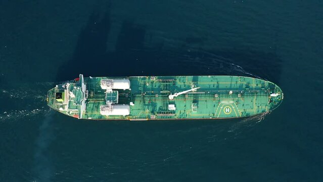 Aerial drone top down: Gas tanker ship sail and transporting liquefied or compressed natural gas, CNG, LNG. Petrochemical tanker vessel cruising open sea