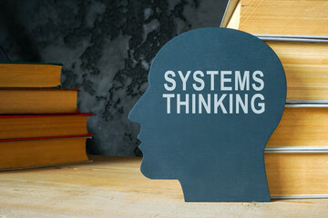 Systems thinking sign on the head shape and books.