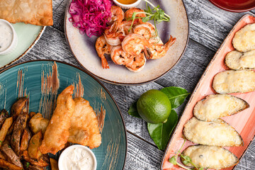Table with various snacks, snacks for everyone on a wooden white background