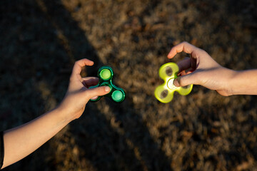 Child's hand playing with a fidget spinner toy