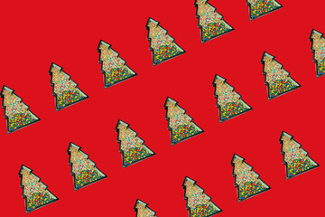 Christmas tree shaped frame filled with many colorful candy sprinkles on red background with copy space. Creative New Year wallpaper pattern idea. Flat lay lay out party theme.