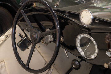 Steering wheel with dashboard in the interior of a sport-style vintage car