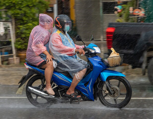 Fototapeta na wymiar Mototaxi is driving with a passenger in heavy rain, Thailand