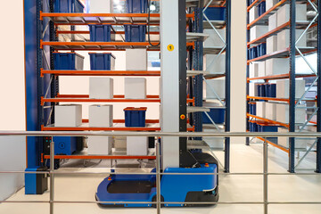 Automated warehouse cart. Forklift robot. Fragment of modern forklift. Equipment for automatic collection of orders. Racks with boxes in warehouse building. Robotic warehouse processes.
