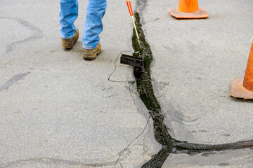 An asphaltic joint crack needs to be sealed in restoration work asphalt road surface