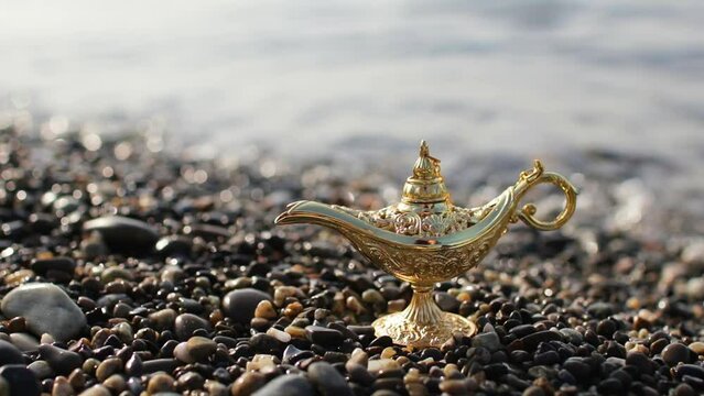 Old Arabian lamp on the beach by the sea, magical Aladdin lamp close up