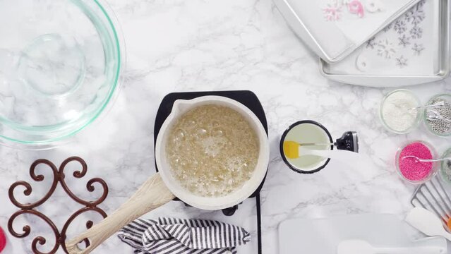 Time lapse. Flat lay. Step by step. Caramelizing sugar in a small cooking pot over the small electric stove.