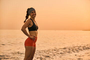 young smiling woman enjoying  the beach at the sunset