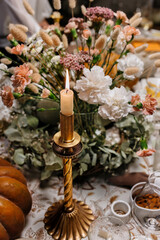 Autumn Decoration and serving of the festive table with autumn decor, candles and flowers and pumpkins.
