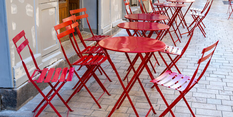 red tables with chairs of a street cafe