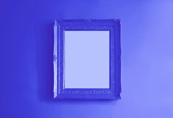 Sapphire colored antique empty photo frame isolated on gradient blue colored wall