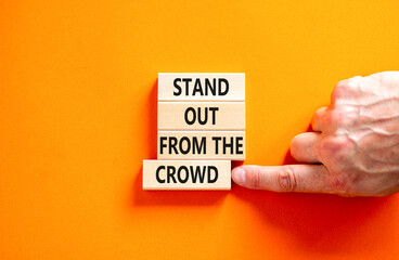 Stand out from the crowd symbol. Concept words Stand out from the crowd on wooden blocks on...