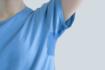 Sweat under the arm. Close-up of  sweat stain on a blue t-shirt.