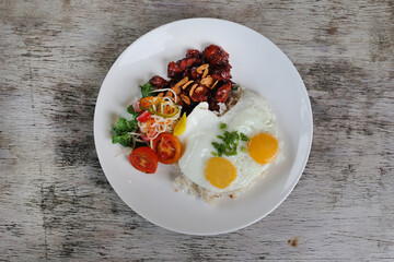 Homemade Chicken Tocino with sunny egg served in dish isolated on wooden background top view of breakfast