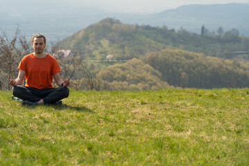 Fototapeta na wymiar Young man do yoga on the rock peak. Meditation