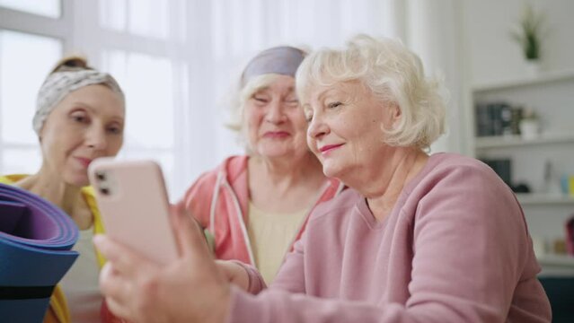 Happy senior women talking selfie during workout, friends having fun at home