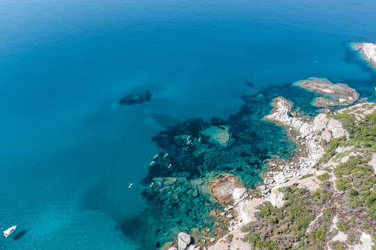 Aerial view of people doing kayak along the coastline near Cumpoltitu Beach, Oristano, Sardinia, Italy.