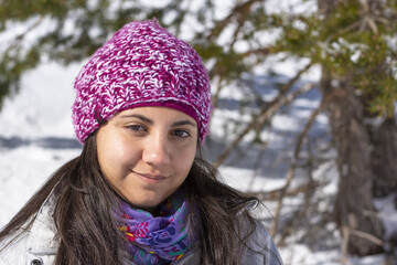 Adolescente con gorro de lana y bufanda en montaña nevada