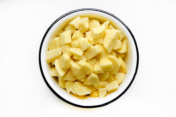 Fresh peeled potatoes in slices in a white dish on a white background. Delicious clean potatoes.