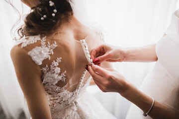 Hands of bridesmaids on bridal dress. Happy marriage and bride at wedding day concept