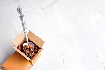 Heart shaped teaspoon and roasted coffee beans