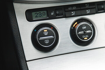 Illuminated button for activated dual-zone climate control and windshield defrost in the car.