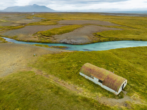 Aerial top view of river Sanda with overnight cabin in the highlands of Iceland.