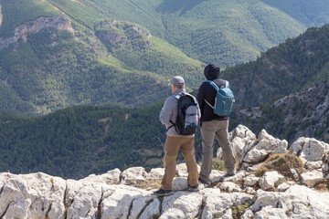 Dos excursionistas observando las vistas desde el pico de una montaña