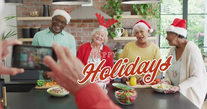 Animation of christmas greetings text over person taking photo of diverse friends at christmas