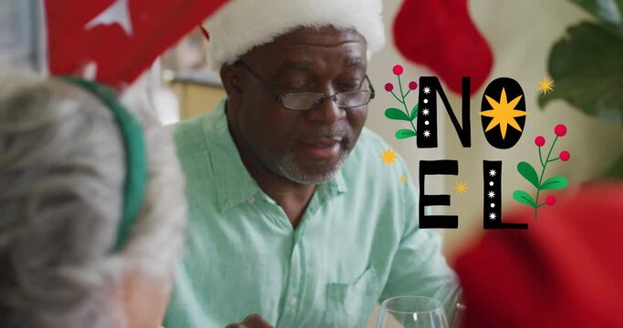 Animation of christmas greetings text over senior african american man at christmas meal table