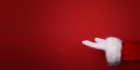 Santa Claus hand presenting your text, product, advertisement on a red background.Mockup. Copy space. Banner