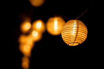 Lampions in orange vor schwarzem Hintergrund geringe Schärfenebene