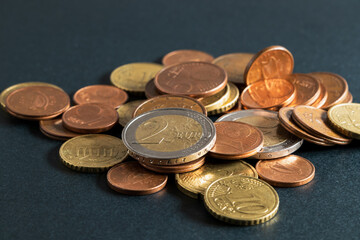Euro coins spilled on the table. Euro coins, cents on black background. Soft focus
