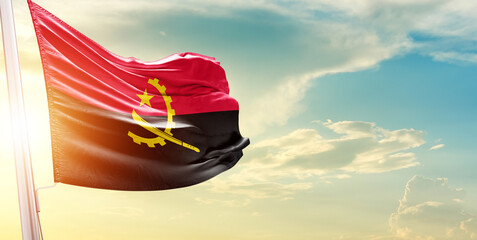 Angola national flag cloth fabric waving on the sky - Image