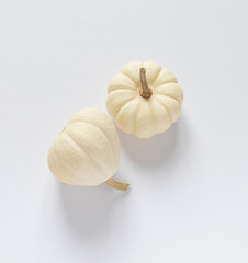 White pumpkins on the white table. Thanksgiving or Halloween composition top view. 