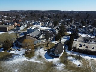 Aerial shot of a residential area with small buildings and a parking lot during winter