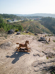 Wooden swing horse on a sightseeing with views to the mountain