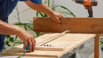 Carpenter Measuring a Wooden Plank