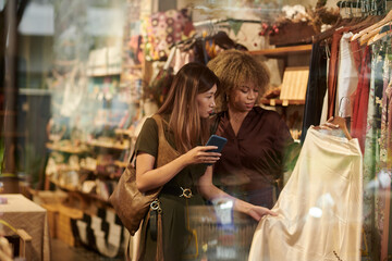 Woman choosing clothes together with designer
