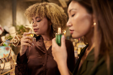 Women smelling perfume at store