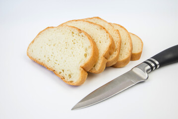 sliced bread and a knife on a white background. White bread slices