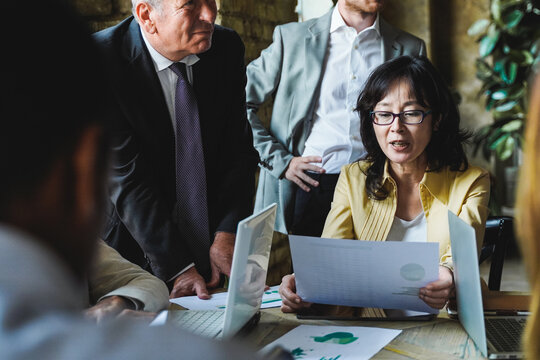 Multiracial Business People Working On Green Sustainable Development Meeting Inside Office - Focus On Asian Senior Woman